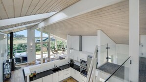 A modern kitchen with large windows, a dining area, and a view of the outdoors. - Stunning home in Hjørring with WiFi (Hjørring)