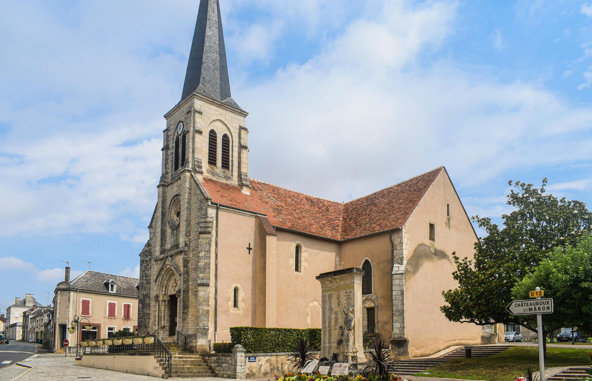 A historic church with a tall spire, a clock tower, and a stone facade.