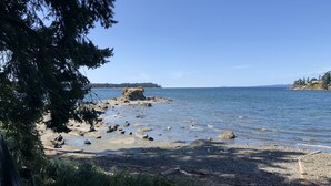 A rocky shoreline with a clear view of the water and distant land. - Pacific Shores Resort - Oceanfront & Amenities Included!!! (Nanoose Bay)