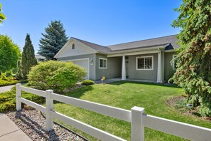 A two-story house with a front yard, a white fence, and a driveway. - *PRIVATE LEISURE POOL* 3bd 2ba Home Near Bypass&Amenities (Kalispell)