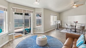 A spacious living area with a large round rug, a brown leather sofa, and a dining table with chairs. - *PRIVATE LEISURE POOL* 3bd 2ba Home Near Bypass&Amenities (Kalispell)