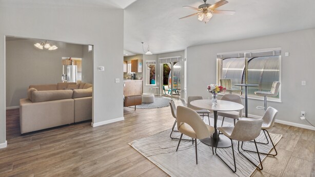 A spacious living area with a modern kitchen, a dining table with chairs, and a ceiling fan. - *PRIVATE LEISURE POOL* 3bd 2ba Home Near Bypass&Amenities (Kalispell)