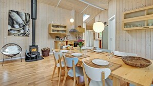 Ein gemütliches Holzinterieur mit Essbereich, Kamin und Küche.