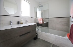 A modern bathroom with a glass-enclosed shower, a vanity with a mirror, and a bathtub. - Nice home in Saint-Pabu (Saint-Pabu)