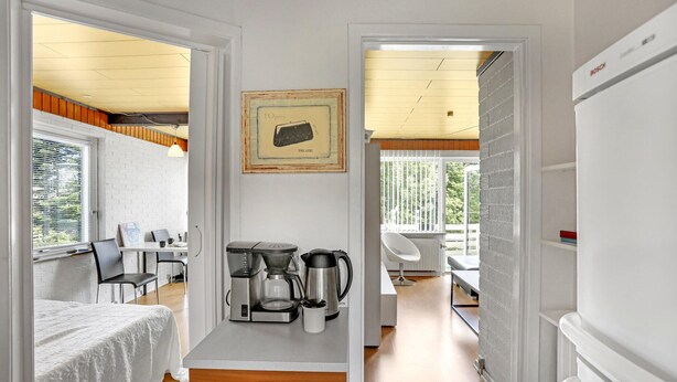 Eine kompakte, moderne Küche mit Kaffeemaschine, Wasserkocher und Toaster auf der Arbeitsfläche.
