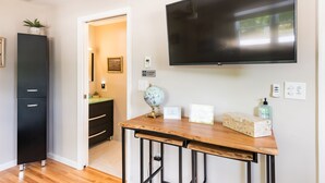 A room with a wooden desk, a black cabinet, a flat-screen TV, a globe, and a bottle of hand sanitizer. - 2 Charleston's Charm Studio 2 is a Private studio 4 miles to Downtown Charleston (Charleston)