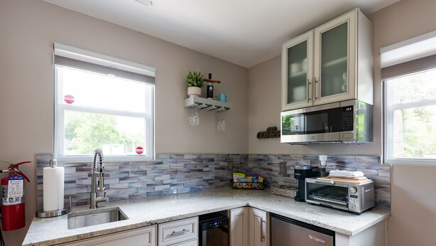 A kitchen with white cabinets, a dishwasher, a microwave, and a toaster. There is a window with a view of trees outside. - 2 Charleston's Charm Studio 2 is a Private studio 4 miles to Downtown Charleston (Charleston)