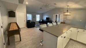A spacious kitchen with a large island, white cabinetry, and a ceiling fan. - Punta Gorda Isles Home -Waterfront Canal,Private Pool, Bird Section, gulf access (Punta Gorda)