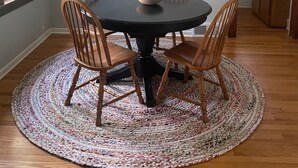 A dining area with a round table, four wooden chairs, a woven rug, and a chandelier. - Cute house close to hospital, UW, shops, bike trails and restaurants (Madison)