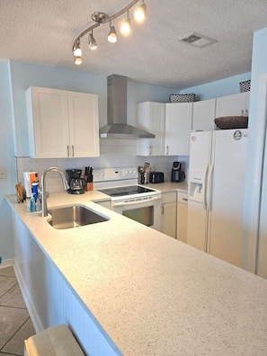 Prepare meals in a well-equipped kitchen with a central island and ample counter space.
