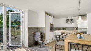 Una cocina moderna con comedor, que cuenta con un amplio ventanal, horno empotrado y refrigerador.