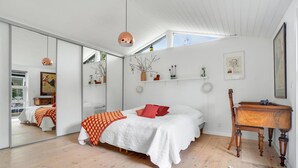 A bedroom with a bed, a wooden desk, a mirror, and a skylight. - Beautiful home in Gilleleje with sauna (Gilleleje)