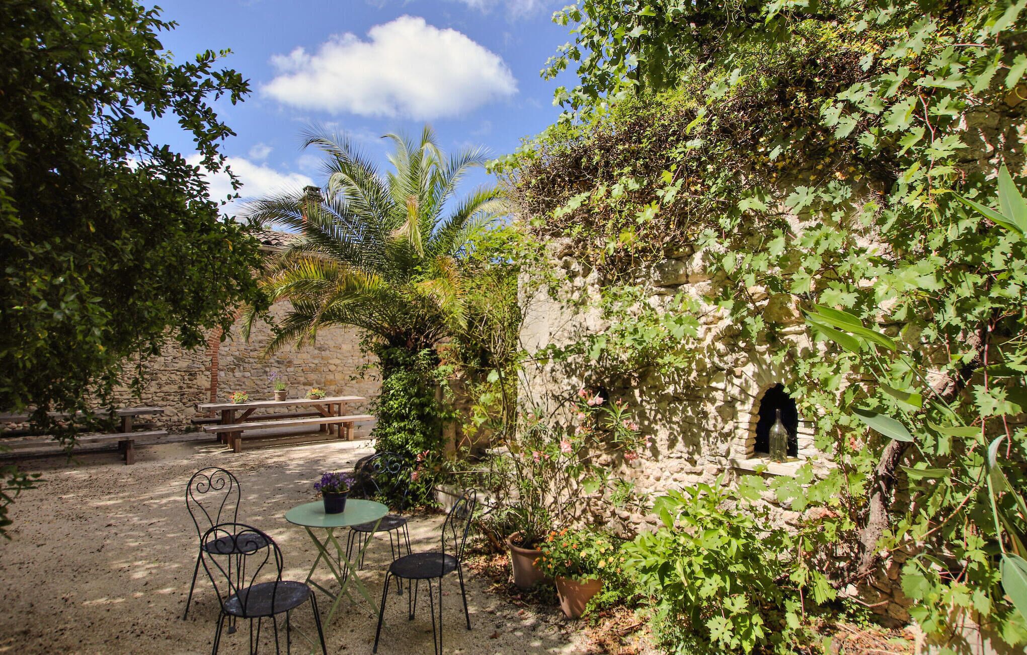 A rustic outdoor seating area with stone walls and greenery.