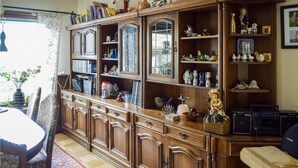 A traditional wooden cabinet with multiple shelves and drawers, containing various decorative items and books.