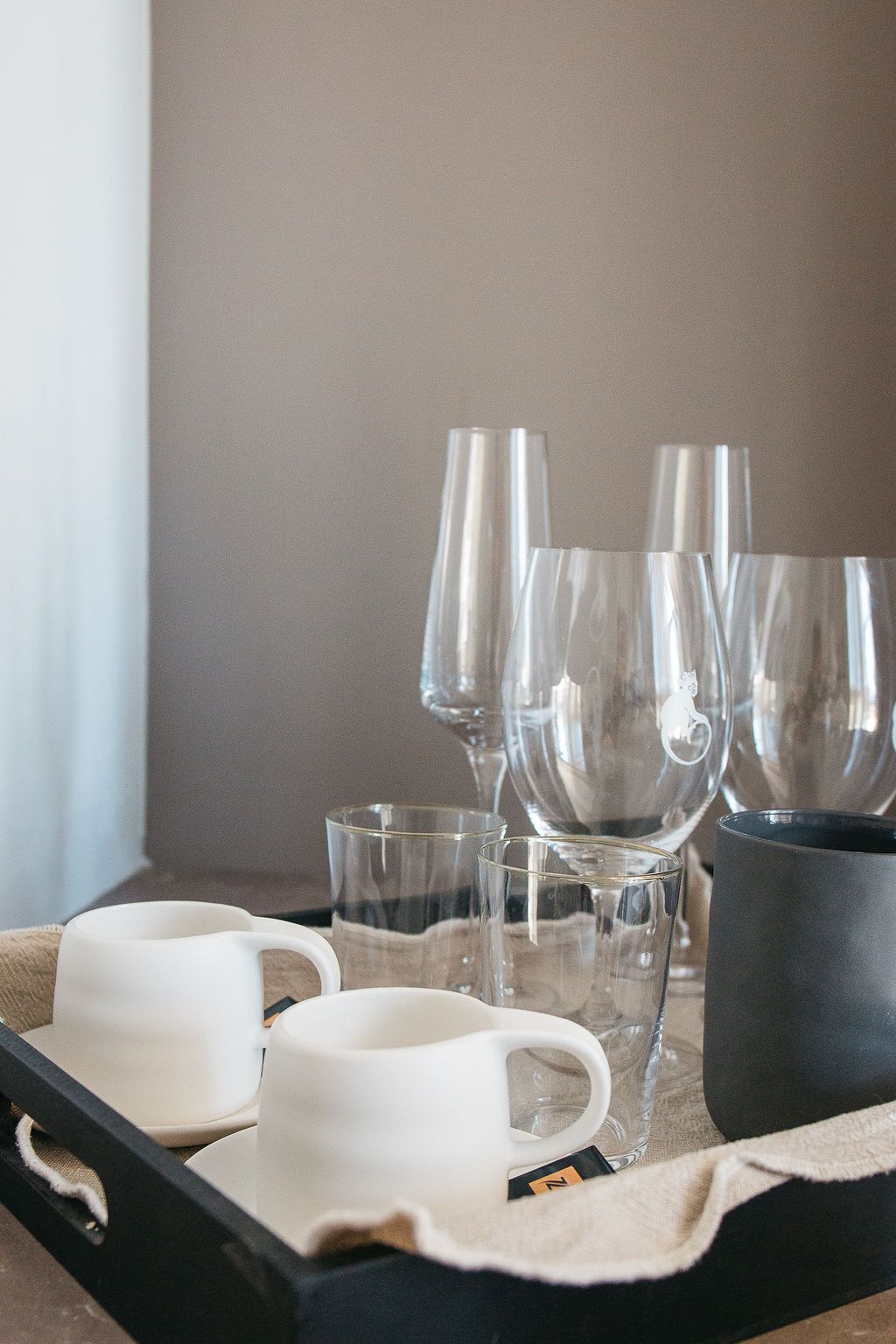 A tray with various glassware and a mug on a table.