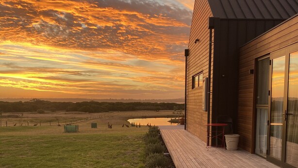A modern building with a sloped roof and a wooden deck. - Majuba Country Lodge (Kalgan)