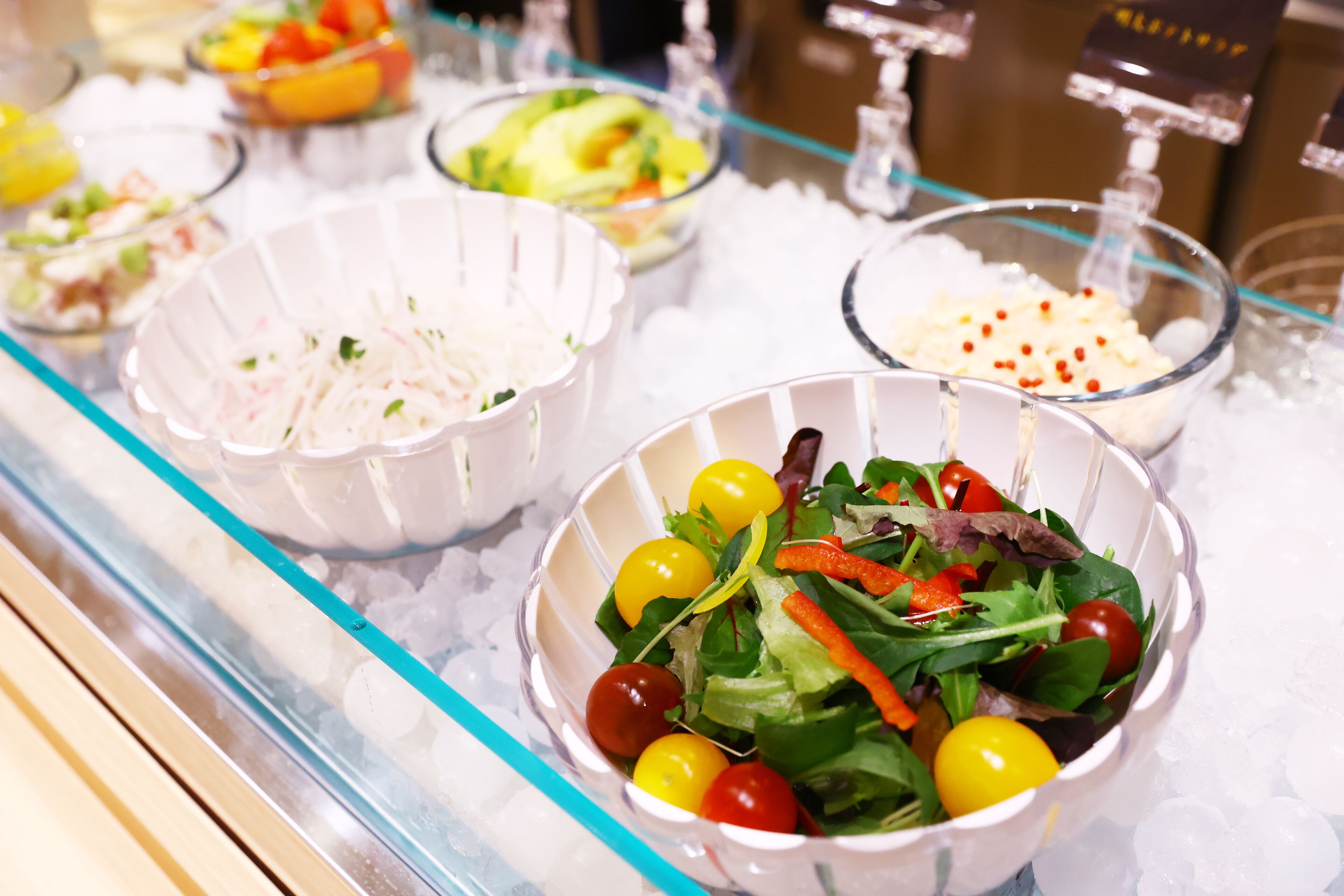 A buffet with various dishes including salads, fruits, and other food items.