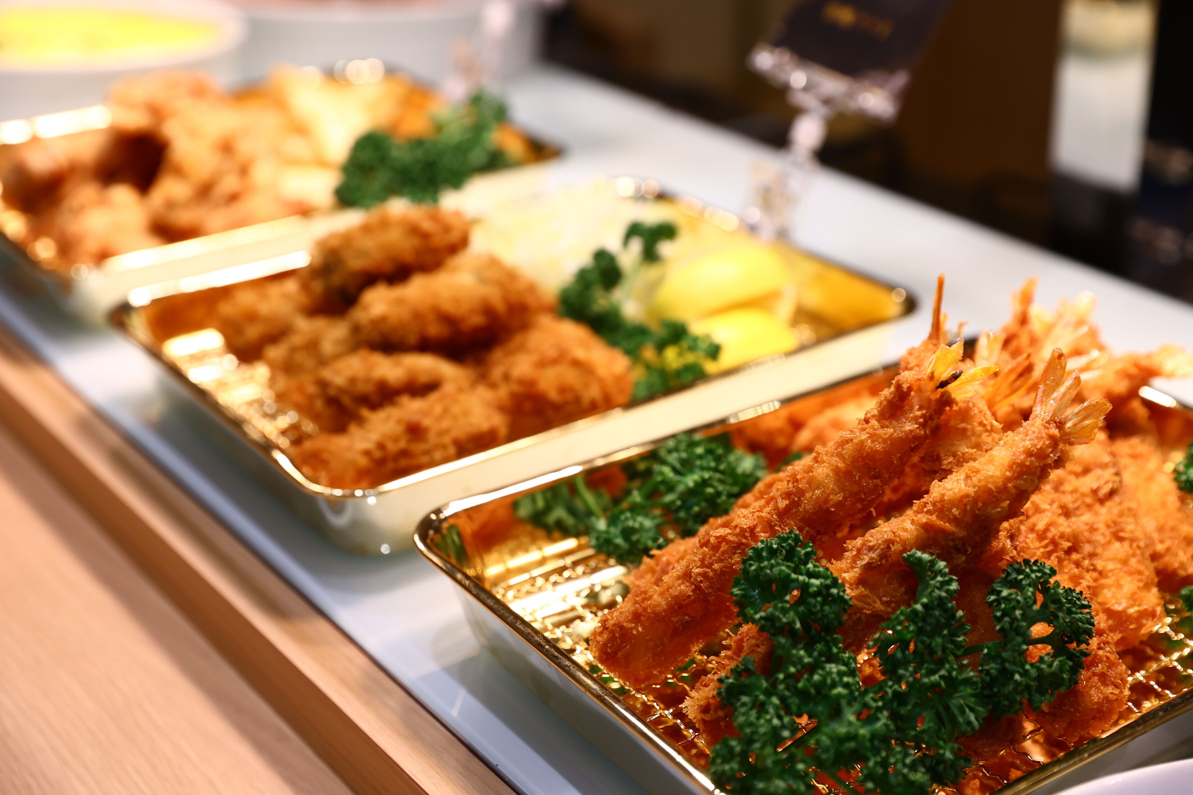 A buffet with various dishes including fried items and garnished with parsley.