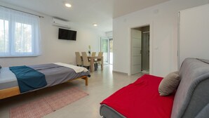 Ein modernes Schlafzimmer mit zwei Betten, einem Essbereich und einem Badezimmer.