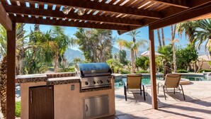 An outdoor patio with a built-in grill, a pool, and lounge chairs. - Private Oasis Overlooking Golf Course  (Palm Desert)