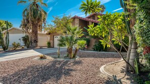 A residential property with a driveway, palm trees, and a variety of desert plants. - Private Oasis Overlooking Golf Course  (Palm Desert)