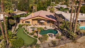 A residential property with a swimming pool, patio, and surrounding greenery. - Private Oasis Overlooking Golf Course  (Palm Desert)