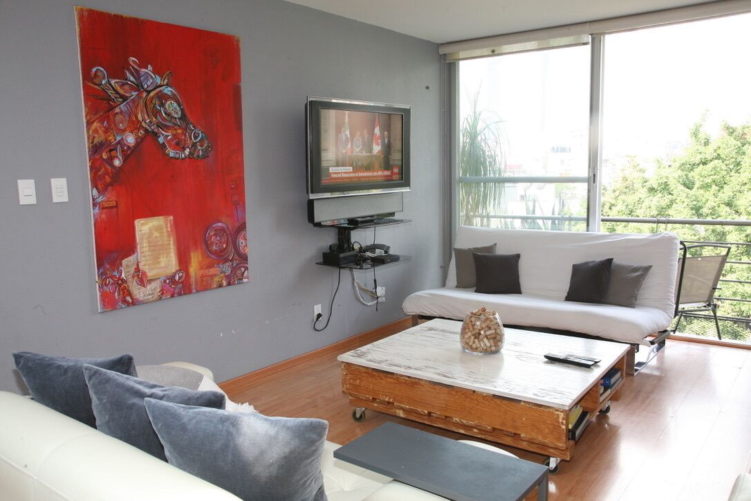 A modern living room with a white sofa, a coffee table, and a television on a stand.