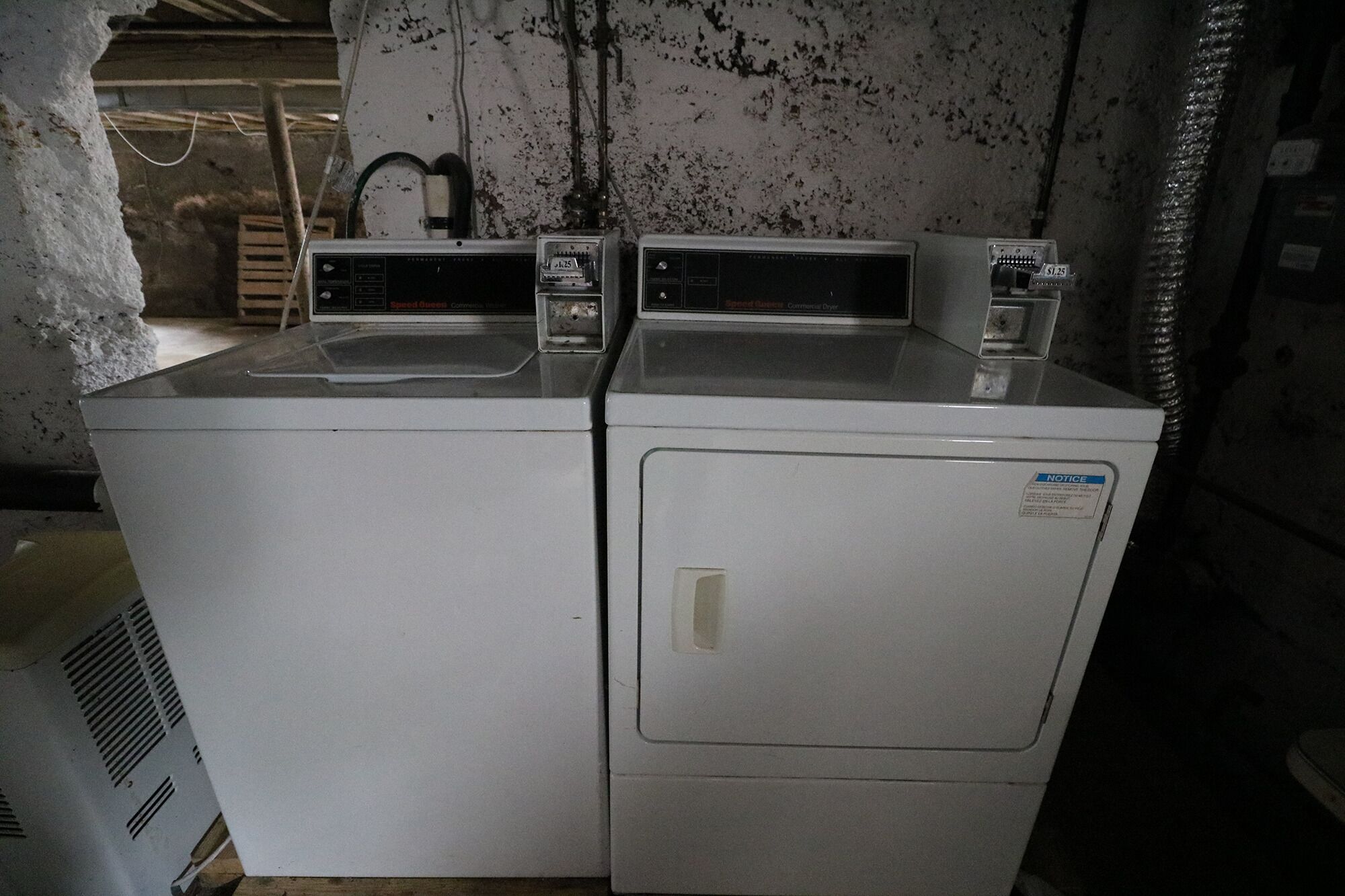 A pair of stacked front-loading washers in a utility room.