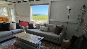 Un salon confortable avec un canapé, une table basse et une vue sur l’extérieur.