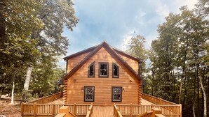 A log cabin with a wooden deck and a staircase leading to the entrance. - Luxe Mountain getaway only 15 minutes from the city! (Greenville)