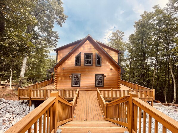 Eine Blockhütte mit einer Holzterrasse und einer Treppe zum Eingang.