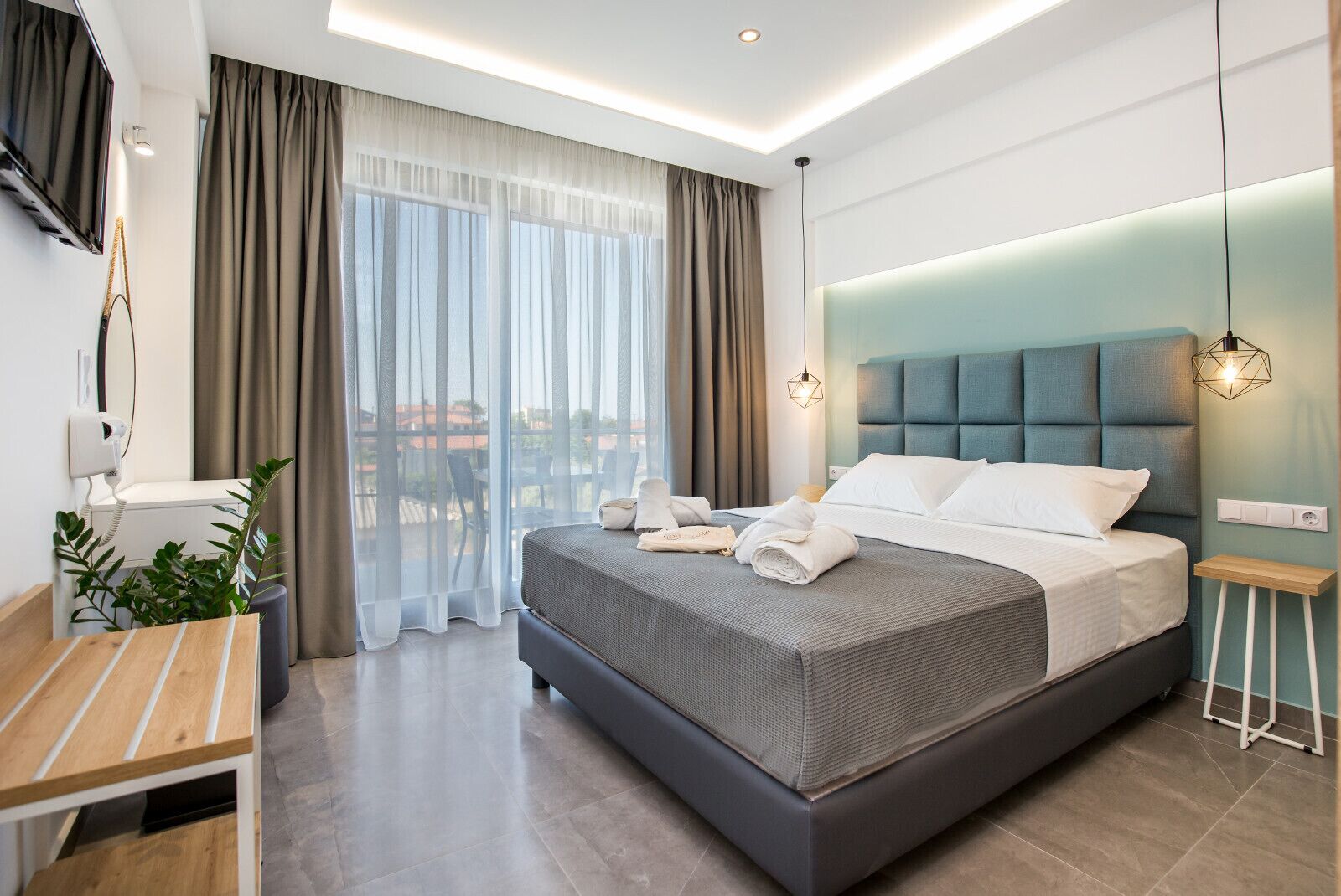 Et moderne hotelværelse med en stor seng, et skrivebord og udsigt til det fri.