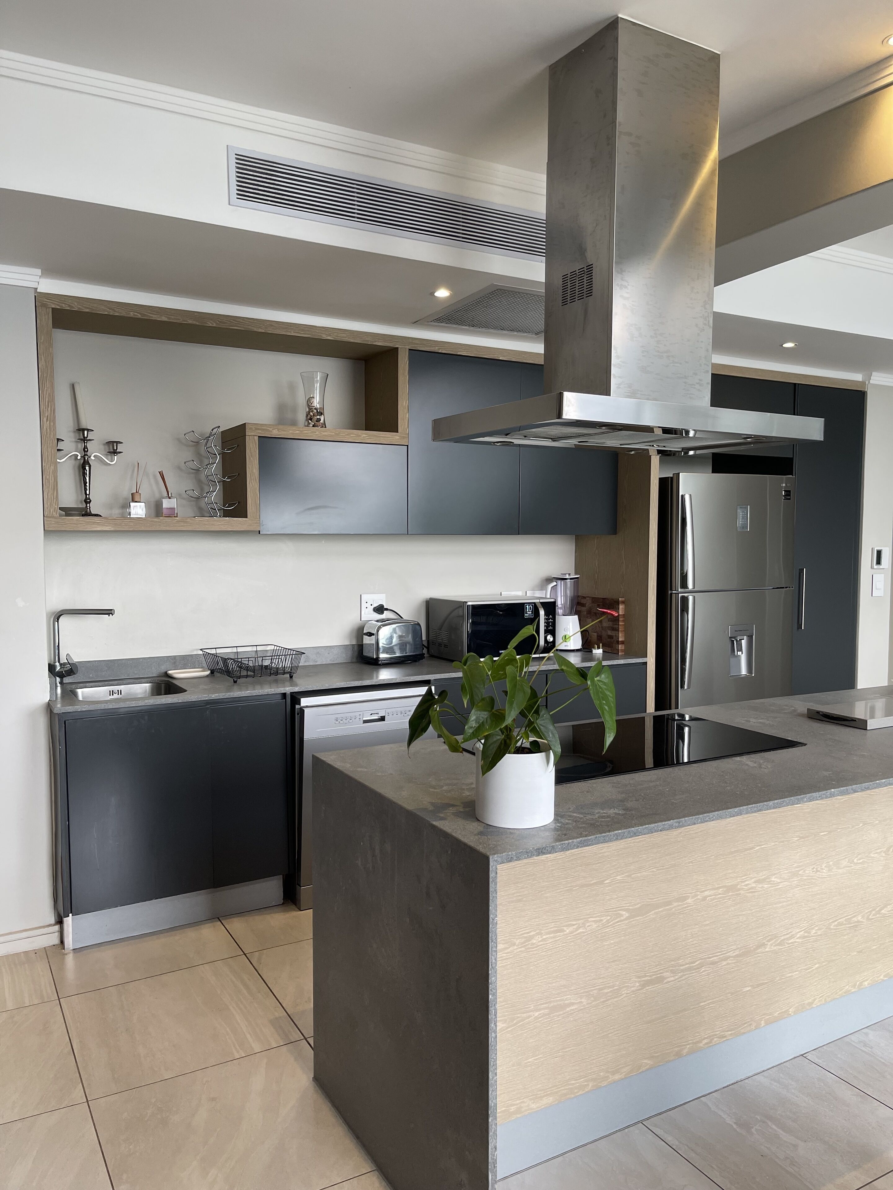 Una cocina moderna con una isla central, electrodomésticos integrados y un diseño elegante.