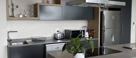 Una cocina moderna con una isla central, electrodomésticos integrados y un diseño elegante.