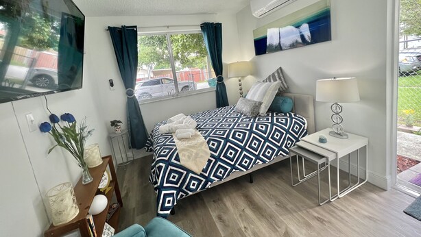 Una camera da letto moderna con un letto, un comodino, una lampada e vista all'esterno.