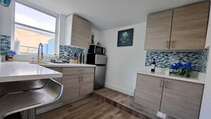 Una cucina moderna con mobili in legno, un frigorifero in acciaio inox e uno schienale piastrellato.