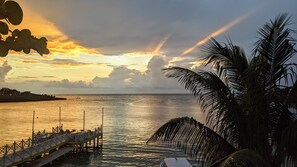 A pier extending into calm waters with a sunset in the background.