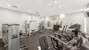 A gym with Cybex equipment, a mirror, and a sign for 'The Yacht Club.' - Modern cozy feeling Next to Beach and Aventura Mall (Miami)