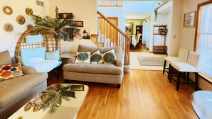 A living room with a sofa, armchair, and a coffee table with a decorative item. - Pocono Escape with huge Pool HOT TUB,GAMEROOM,FIREPIT,near Camelback & Kalahari (Stroudsburg)