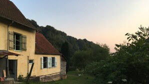 A two-story house with a red-tiled roof and a small garden. - Charming Rustic 2 bedroom annex cottage (Mouriez)