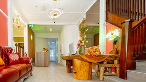 Un interno moderno con un divano in pelle rossa, un tavolino in legno e un neon.