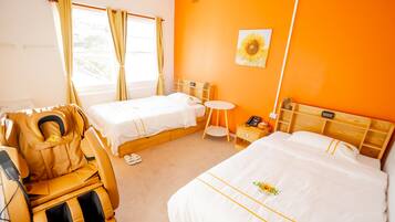 A hotel room with two beds, a massage chair, a small round table, and a wall-mounted phone.