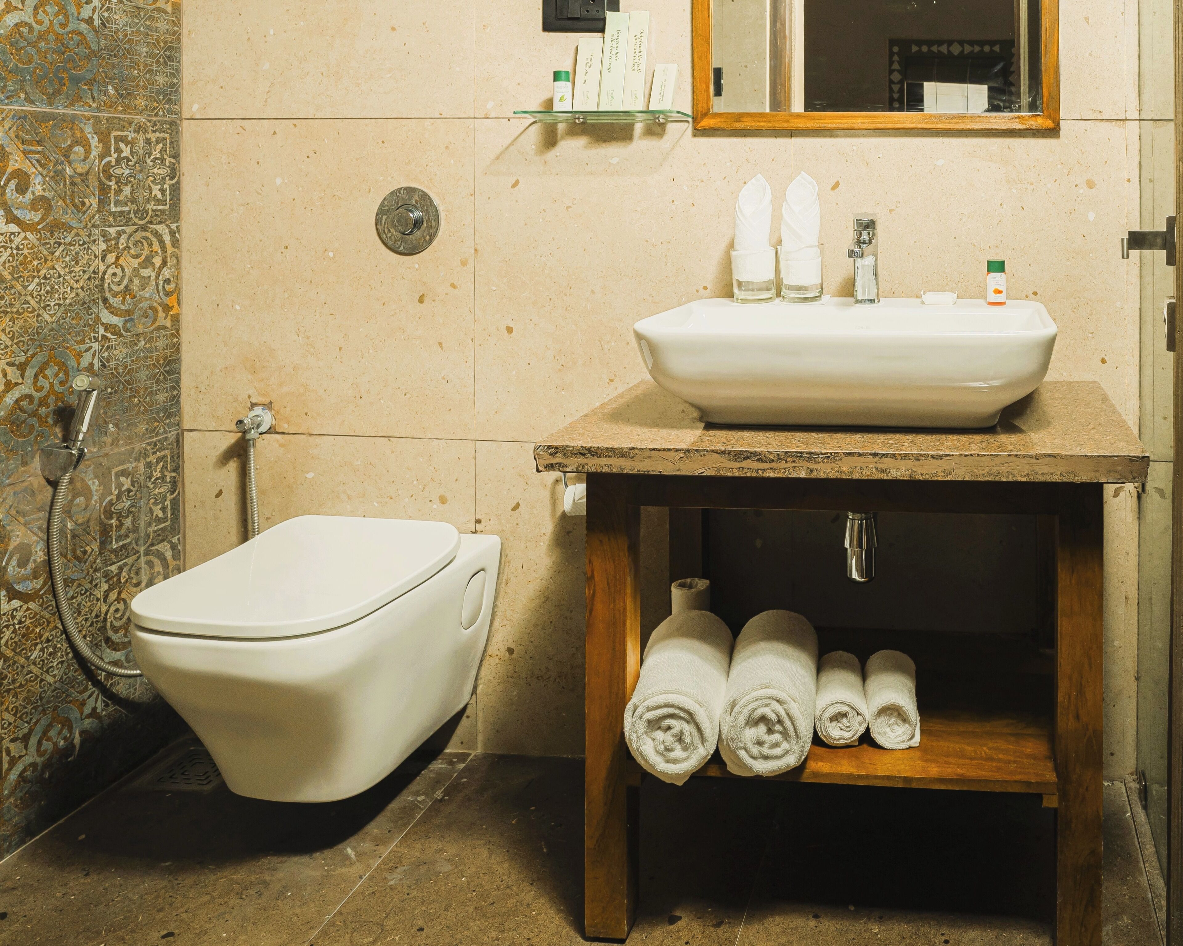 Un baño con inodoro, lavamanos y ducha. Hay toallas y artículos de aseo en el lavamanos.