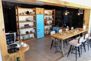 A kitchen with wooden cabinets, a blue refrigerator, and a dining table with chairs.