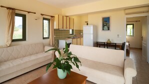 A compact living space with a sofa, a dining table, and a kitchen area. - Villa Luisa Exclusive Residences (Monemvasia)