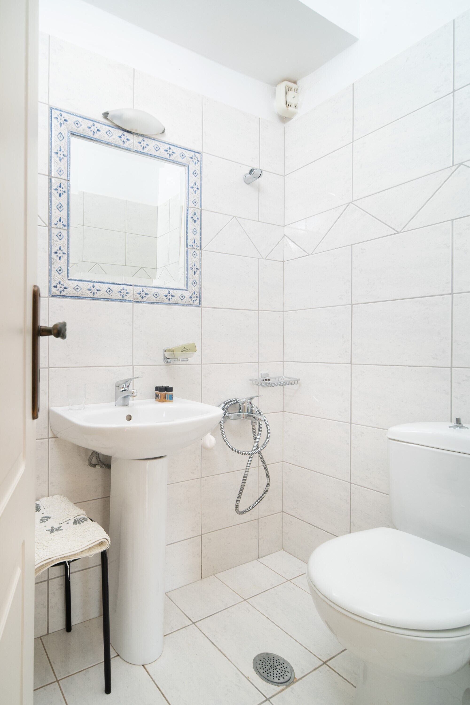 A bathroom with a white sink, mirror, and toilet.