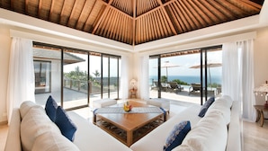 A spacious living area with a wooden ceiling, large windows, and a view of the ocean. - Karang Saujana Estate (Kutuh)