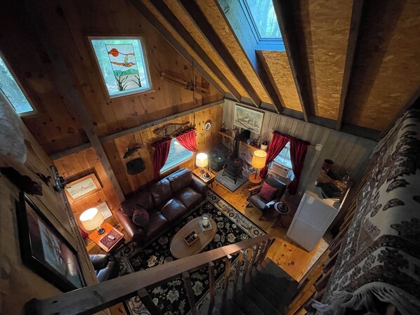A cozy cabin interior with a wooden ceiling, a fireplace, a sofa, and a dining area. - Where the signal is weak, but the connections are strong… (Huntingdon)