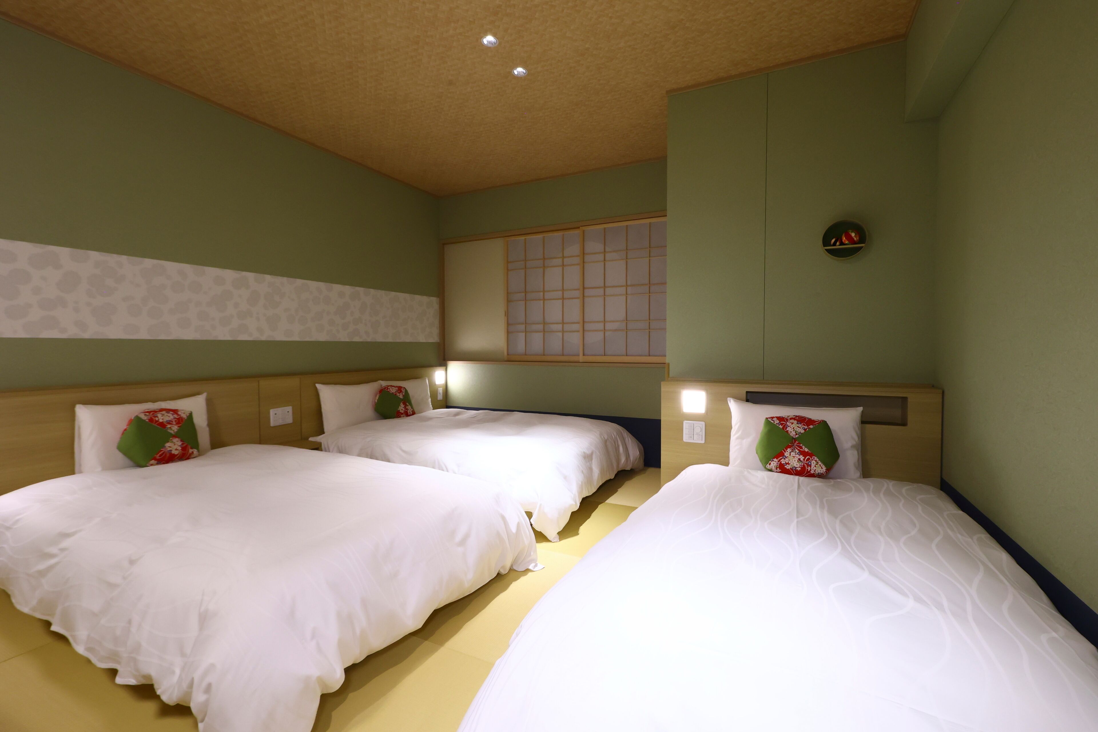 A hotel room with two beds, a wooden headboard, a window with a view, and a wall-mounted clock.