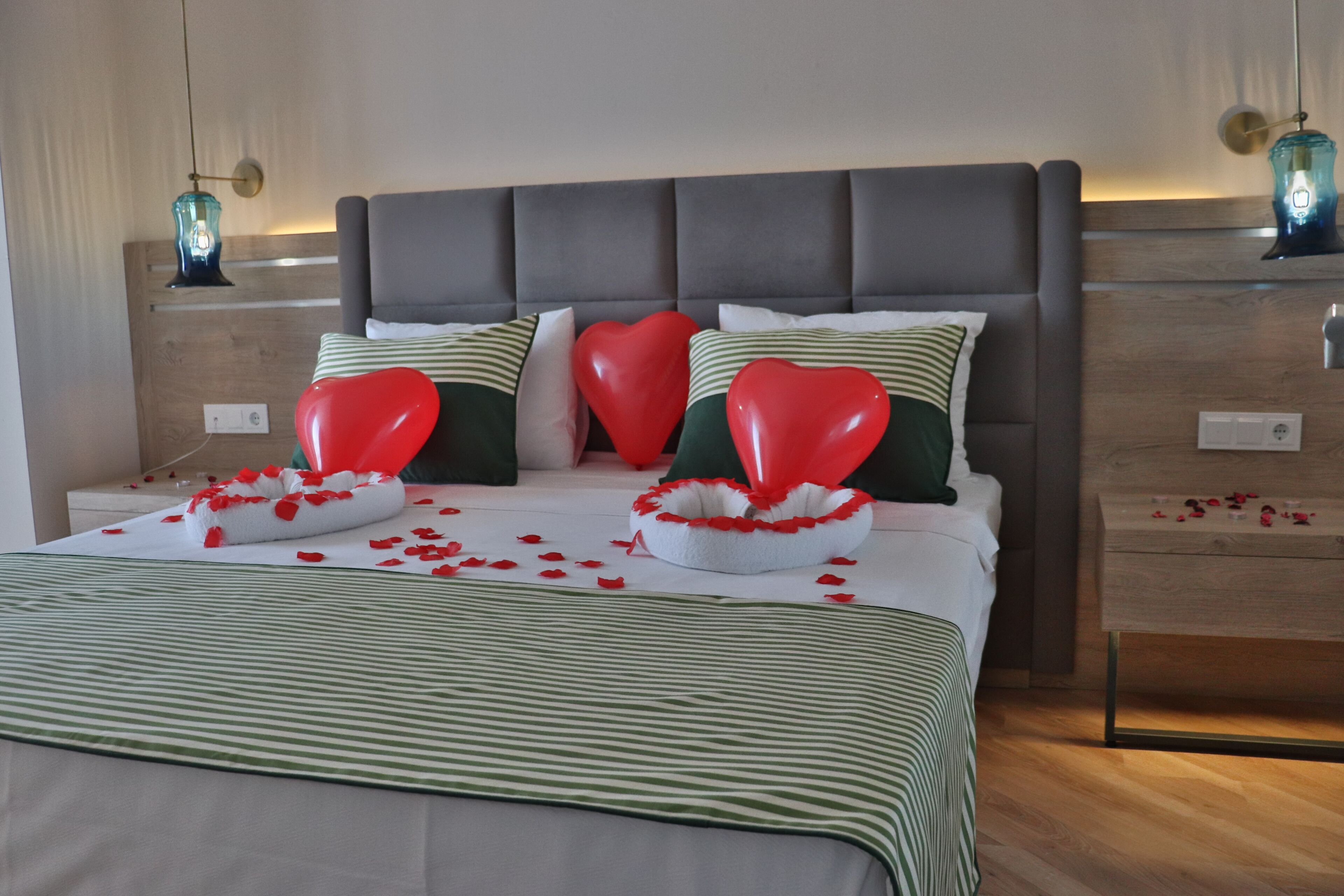 Un dormitorio ordenado con cama, almohadas y mesita de noche.